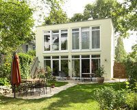 Kubus mit großen Fenstern im Garten
