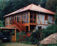 Lehmhaus mit Holzveranda am Hang