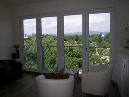 Wohnraum mit großen Fenstern und Blick ins Grüne